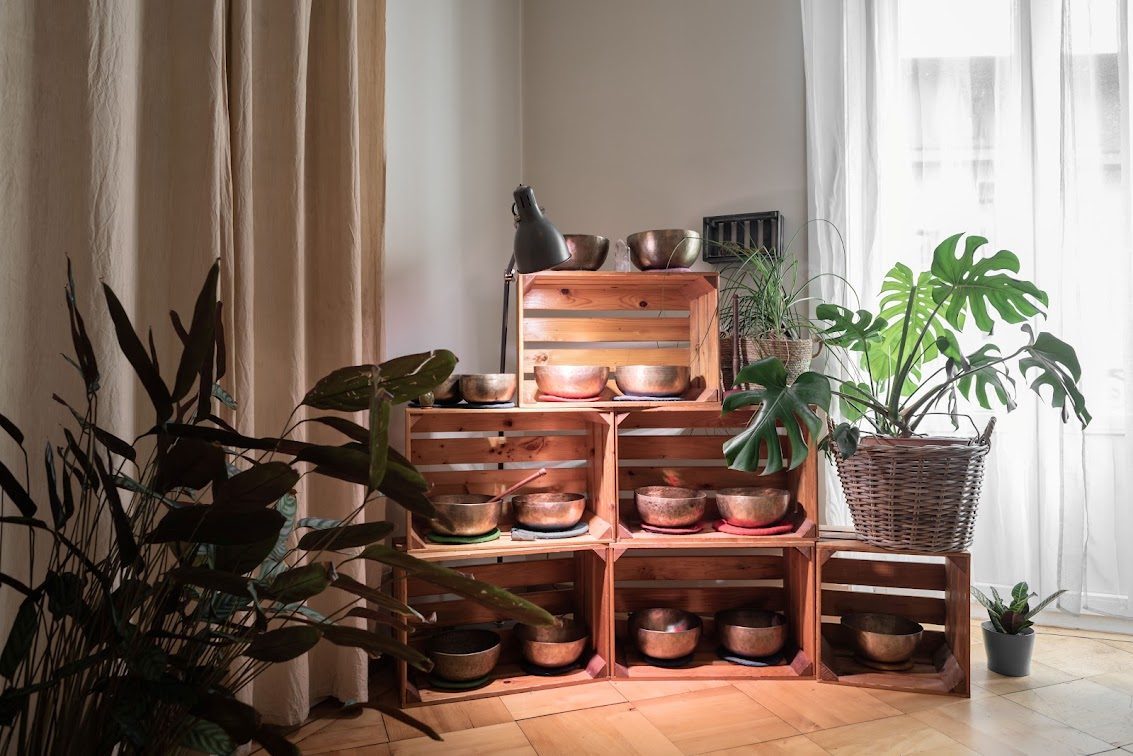 Collection de bols tibétains en laiton rangés sur des caisses en bois dans le cabinet de Séverine Chasles à Neuchâtel
